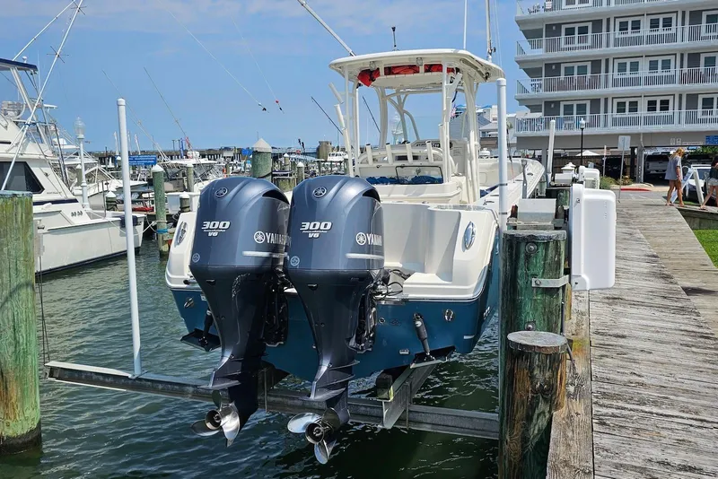 Slide: The Image of 2014 Sailfish 290 CC boat with twin Yamaha 300 V6 engines docked at marina. - 13