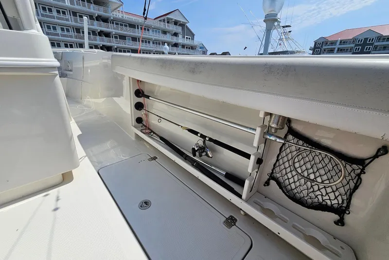 Slide: The Image of 2014 Sailfish 290 CC boat interior with fishing rod storage and netting. - 19