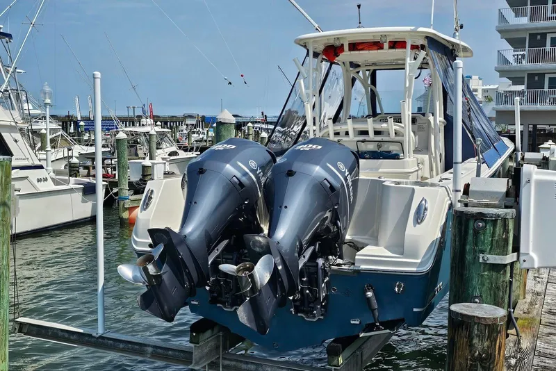 Slide: The Image of 2014 Sailfish 290 CC boat with twin Yamaha outboard motors docked at a marina. - 4