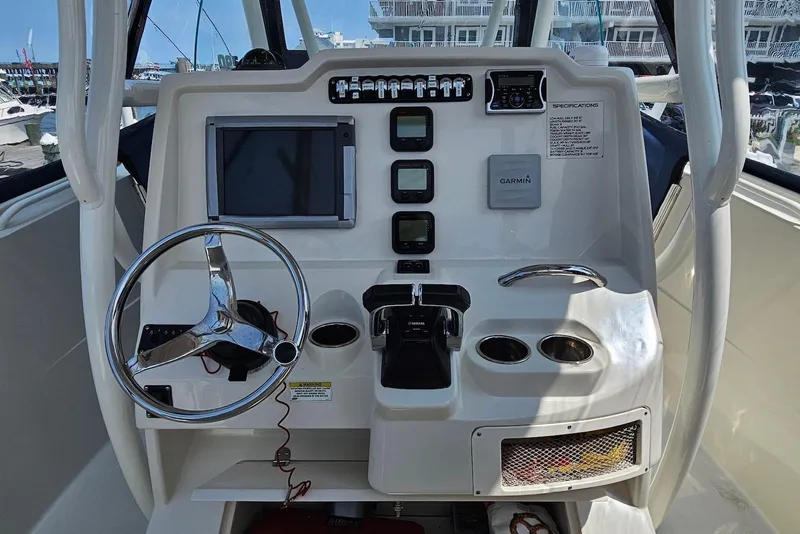 Slide: The Image of 2014 Sailfish 290 CC boat dashboard with steering wheel, controls, and Garmin navigation system. - 7