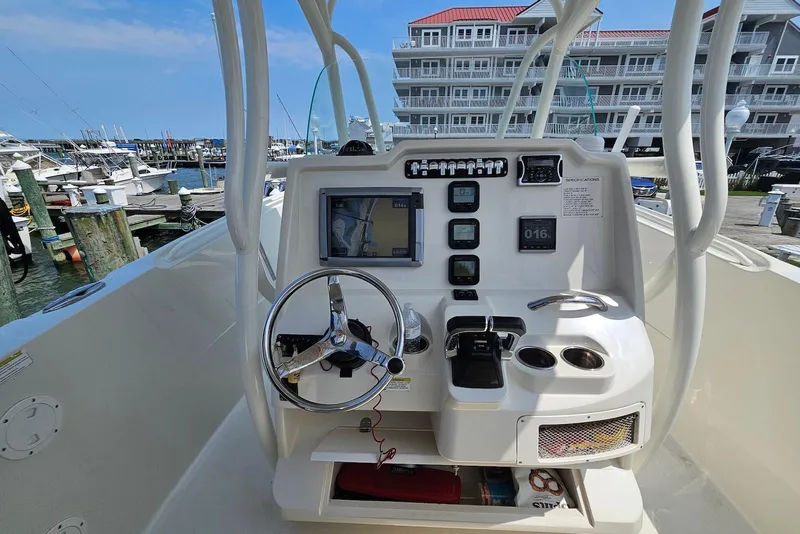 Slide: The Image of 2014 Sailfish 290 CC boat console with steering wheel and navigation equipment at marina. - 8