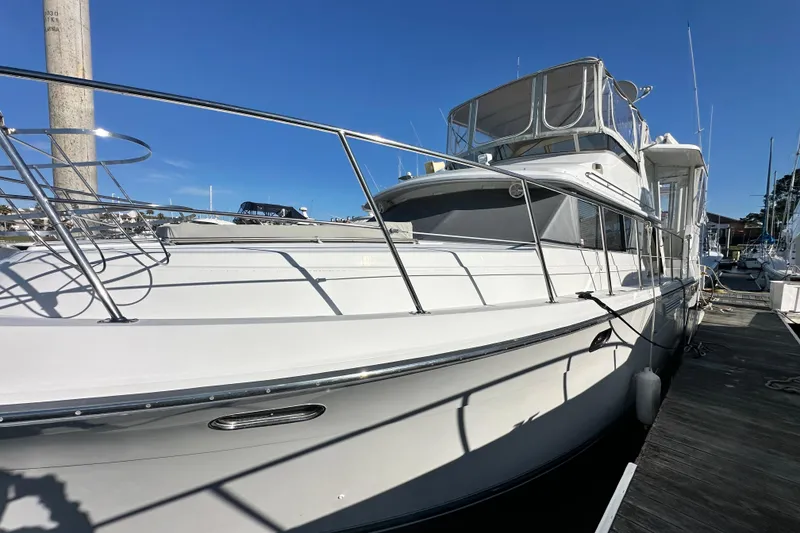 Slide: The Image of 1995 Carver 440 Aft Cabin Motor Yacht docked under clear blue sky. - 1