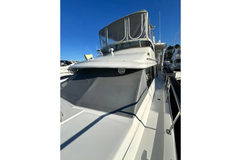 Slide: The Image of 1995 Carver 440 Aft Cabin Motor Yacht docked under clear blue sky. - 11