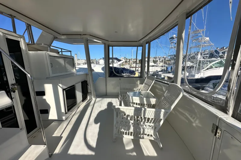Slide: The Image of 1995 Carver 440 Aft Cabin Motor Yacht interior with wicker chairs and marina view. - 17