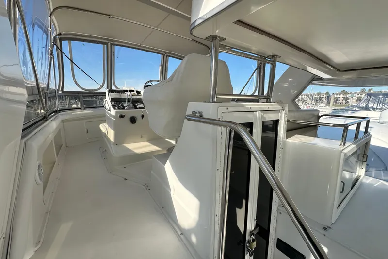 Slide: The Image of 1995 Carver 440 Aft Cabin Motor Yacht helm with panoramic marina view. - 21