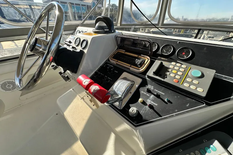 Slide: The Image of 1995 Carver 440 Aft Cabin Motor Yacht helm with steering wheel and control panel. - 26