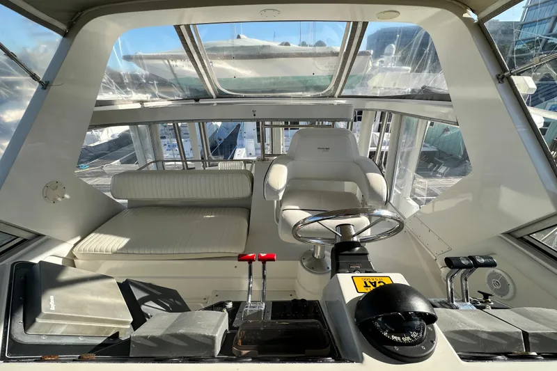 Slide: The Image of 1995 Carver 440 Aft Cabin Motor Yacht helm with steering wheel and controls. - 31