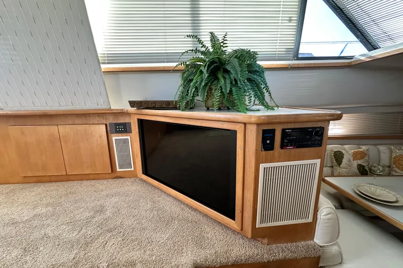 Slide: The Image of 1995 Carver 440 Aft Cabin Motor Yacht interior with entertainment center and potted fern. - 39