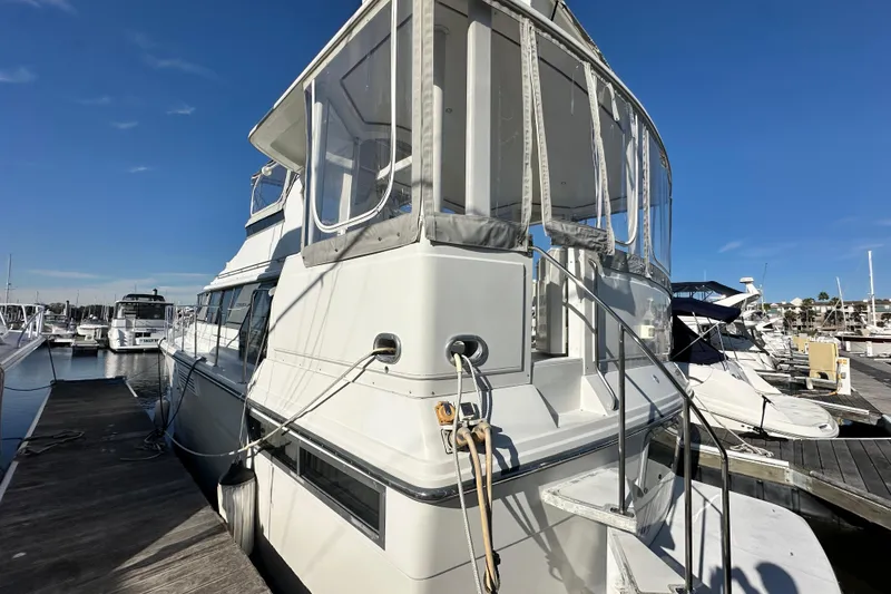 Slide: The Image of 1995 Carver 440 Aft Cabin Motor Yacht docked at marina under clear blue sky. - 4