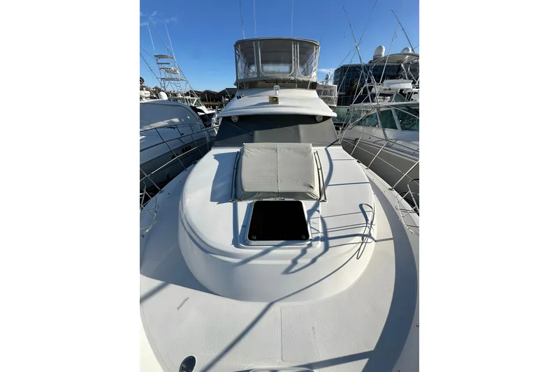 Slide: The Image of 1995 Carver 440 Aft Cabin Motor Yacht, docked, with sun pad and clear sky. - 5