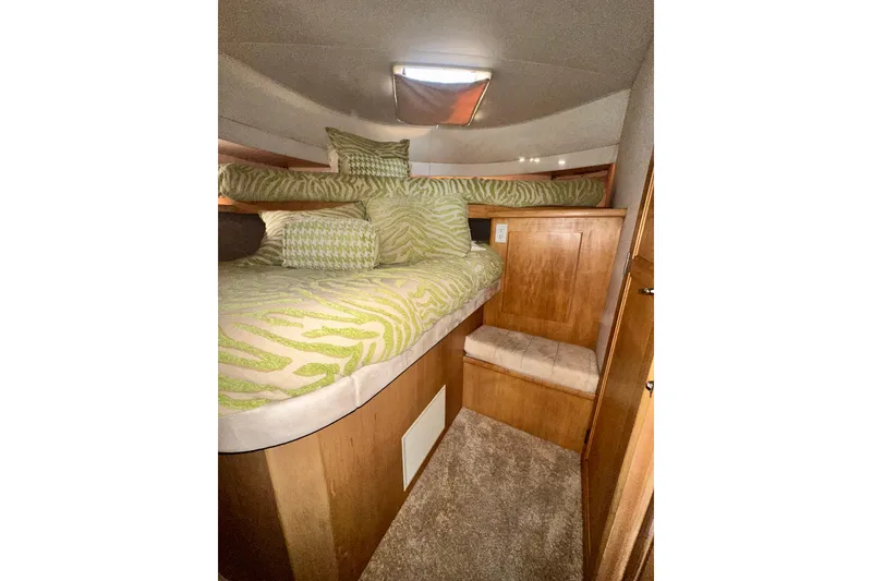 Slide: The Image of 1995 Carver 440 Aft Cabin Motor Yacht interior with cozy bed and green patterned bedding. - 60