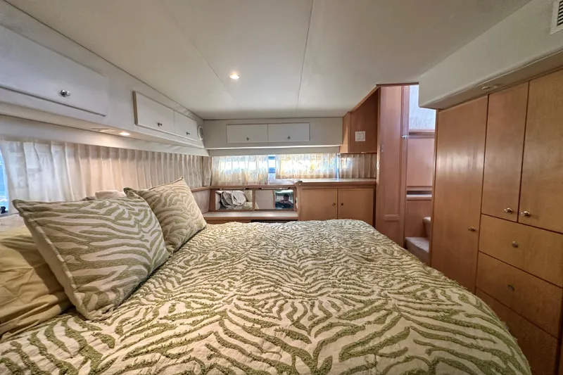 Slide: The Image of Luxurious bedroom interior of 1995 Carver 440 Aft Cabin Motor Yacht with patterned bedding. - 71
