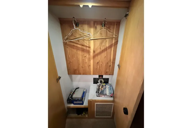 Slide: The Image of 1995 Carver 440 Aft Cabin Motor Yacht closet with hangers and storage shelves. - 77