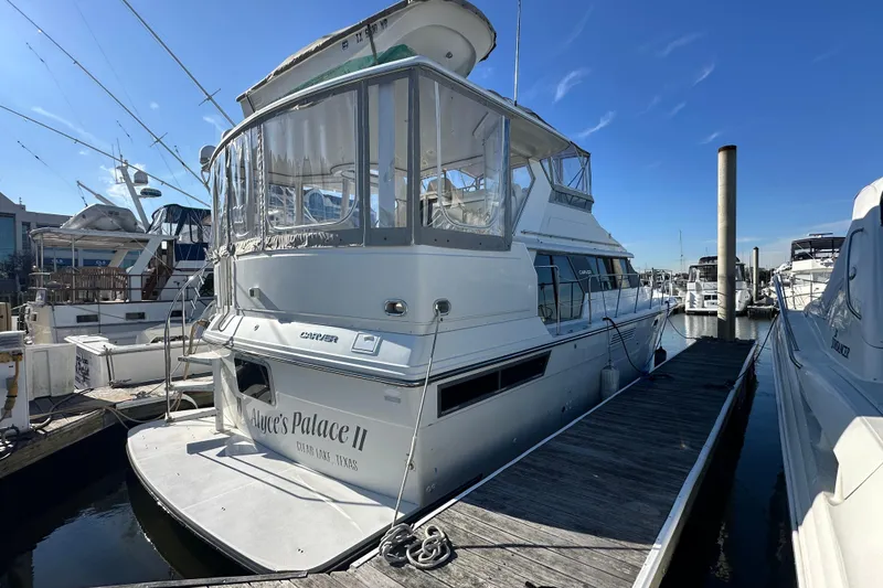 The Image of 1995 Carver 440 Aft Cabin Motor Yacht docked at marina under clear blue sky. - 0