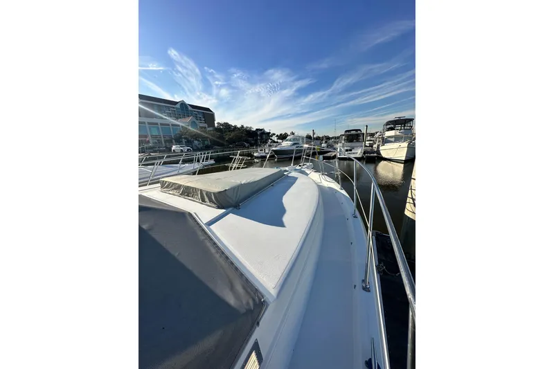 Slide: The Image of 1995 Carver 440 Aft Cabin Motor Yacht docked at marina under clear blue sky. - 10