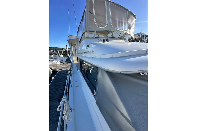 Slide: The Image of 1995 Carver 440 Aft Cabin Motor Yacht docked under clear blue sky. - 12