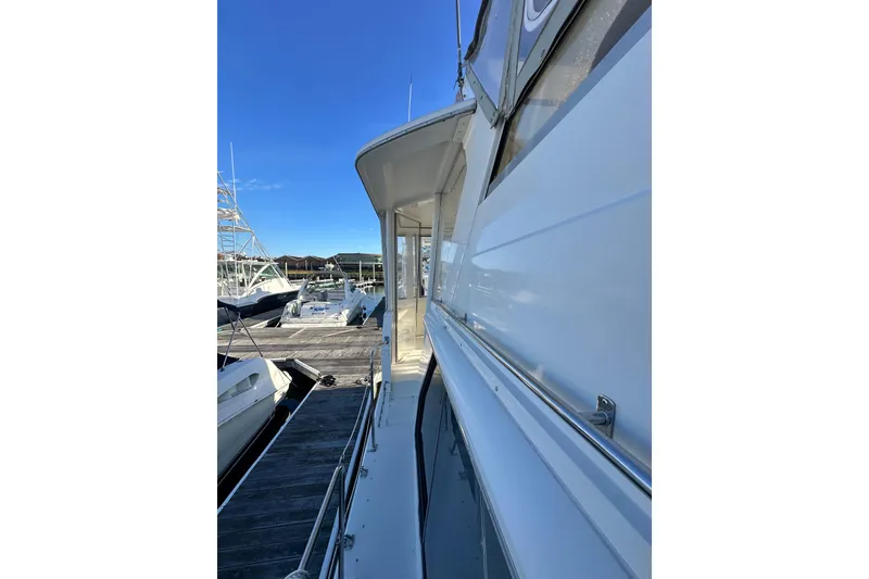 Slide: The Image of 1995 Carver 440 Aft Cabin Motor Yacht docked at marina under clear blue sky. - 13