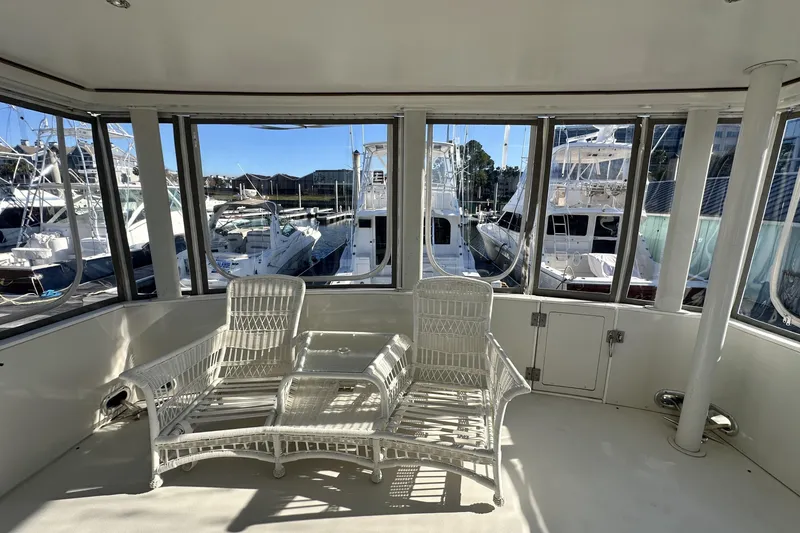 Slide: The Image of 1995 Carver 440 Aft Cabin Motor Yacht interior with wicker chairs and marina view. - 20