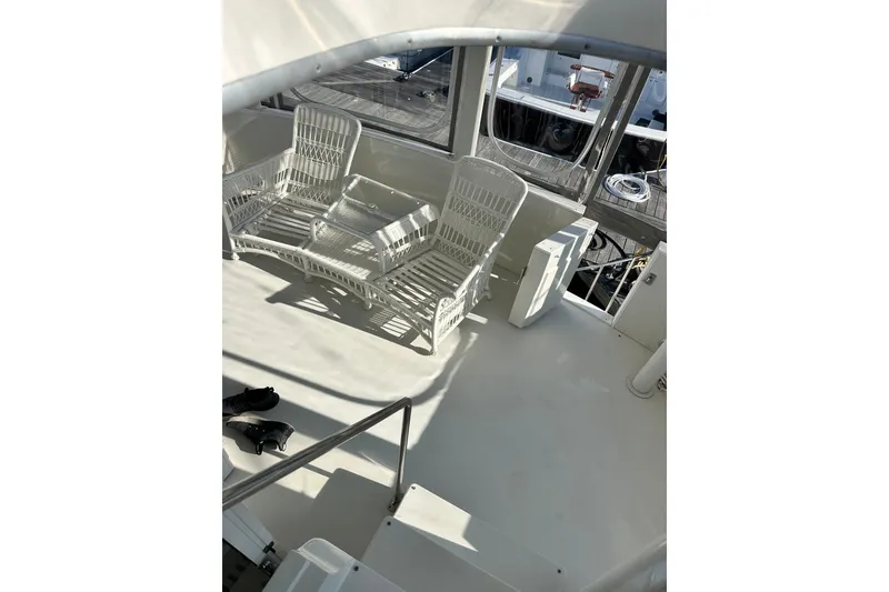 Slide: The Image of 1995 Carver 440 Aft Cabin Motor Yacht deck with white wicker seating. - 22