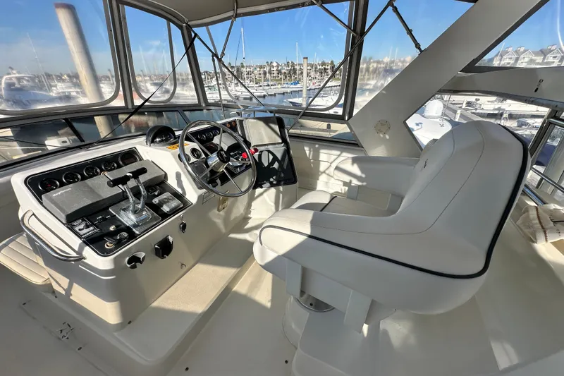 Slide: The Image of 1995 Carver 440 Aft Cabin Motor Yacht helm with steering wheel and controls. - 23