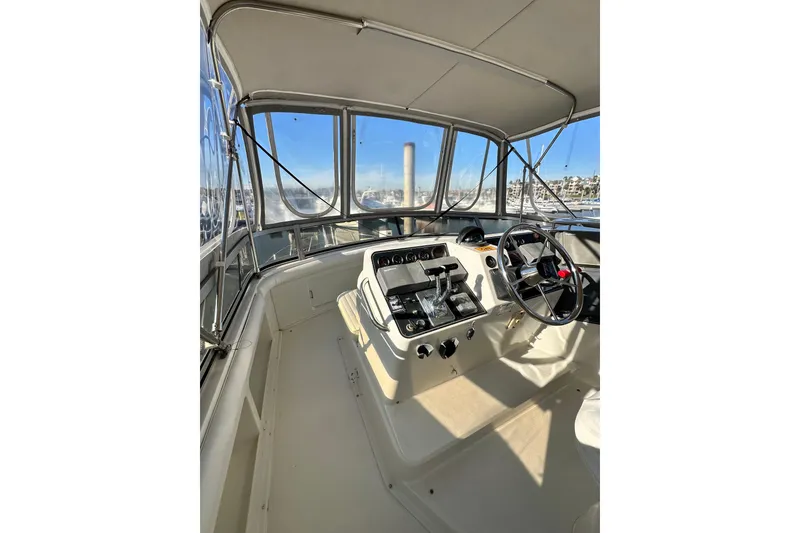 Slide: The Image of 1995 Carver 440 Aft Cabin Motor Yacht helm with steering wheel and controls. - 27