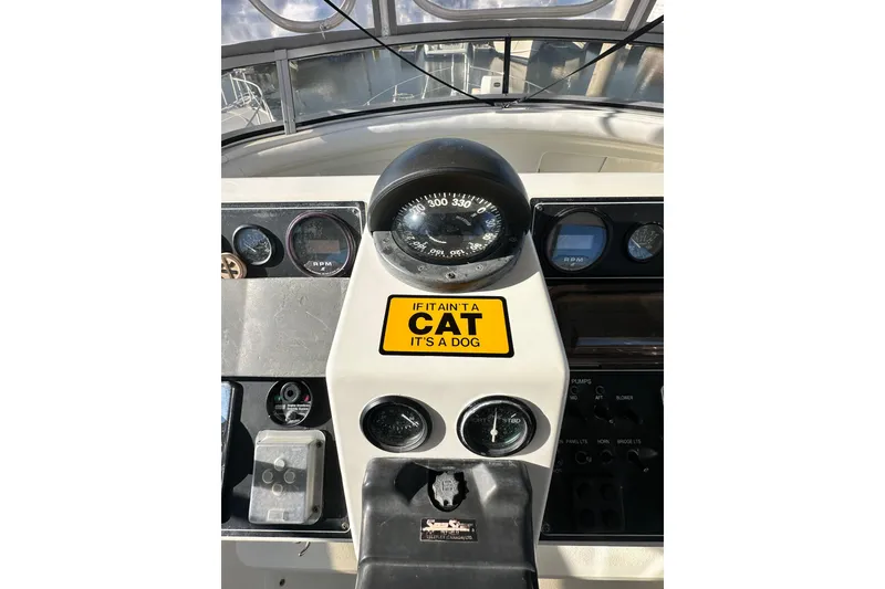 Slide: The Image of 1995 Carver 440 Aft Cabin Motor Yacht helm with humorous cat-themed sign. - 29