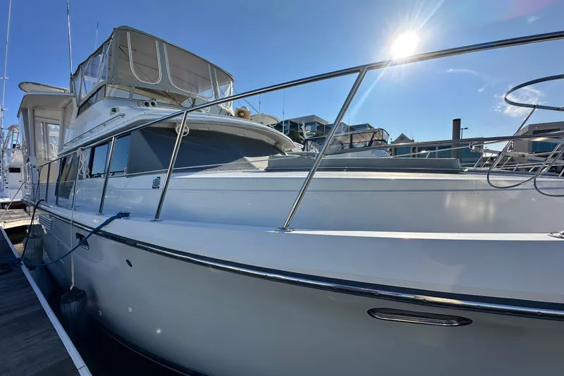 Slide: The Image of 1995 Carver 440 Aft Cabin Motor Yacht docked under clear blue sky. - 3