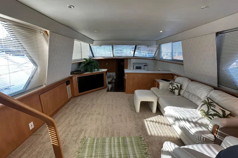 Slide: The Image of Luxurious interior of 1995 Carver 440 Aft Cabin Motor Yacht with plush seating and natural light. - 32