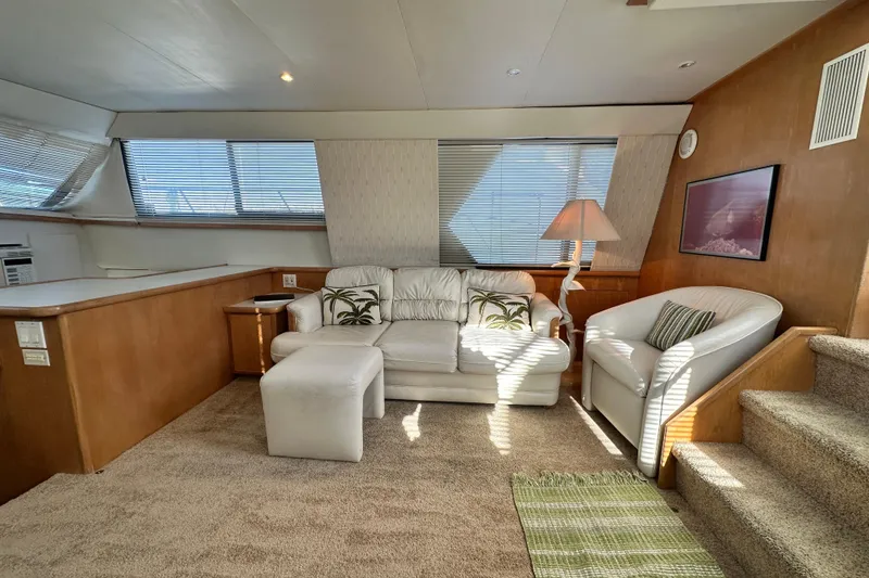 Slide: The Image of Luxurious interior of 1995 Carver 440 Aft Cabin Motor Yacht with plush seating and natural light. - 34