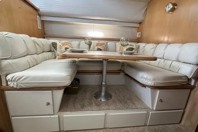 Slide: The Image of 1995 Carver 440 Aft Cabin Motor Yacht interior with cozy dining area and plush seating. - 45