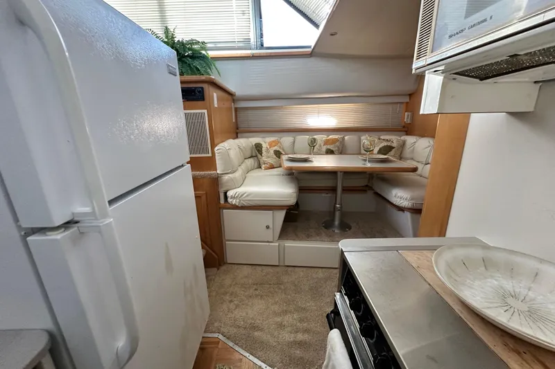 Slide: The Image of 1995 Carver 440 Aft Cabin Motor Yacht interior with dining area and kitchen amenities. - 52