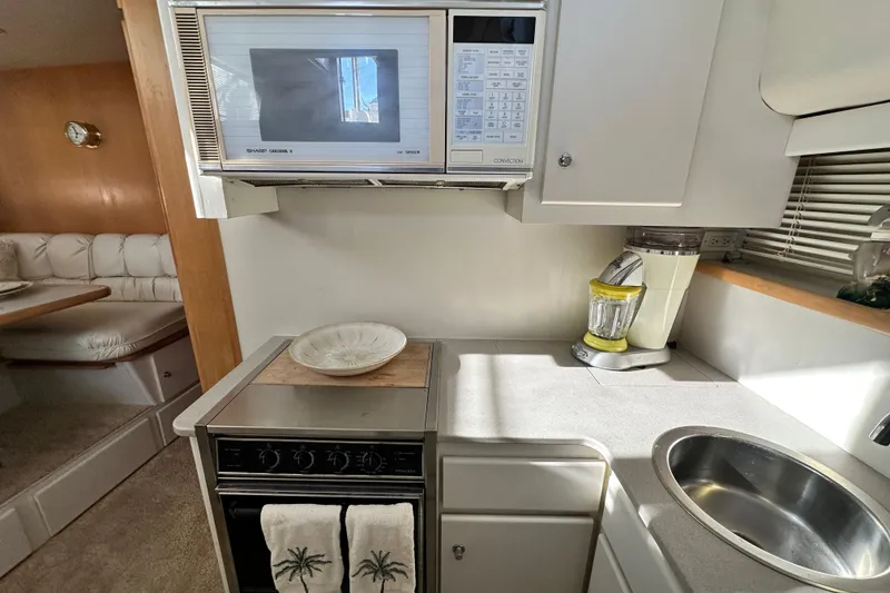 Slide: The Image of 1995 Carver 440 Aft Cabin Motor Yacht kitchen with microwave, stove, and sink. - 53
