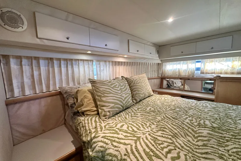 Slide: The Image of Cozy bedroom in 1995 Carver 440 Aft Cabin Motor Yacht with patterned bedding and ample storage. - 70