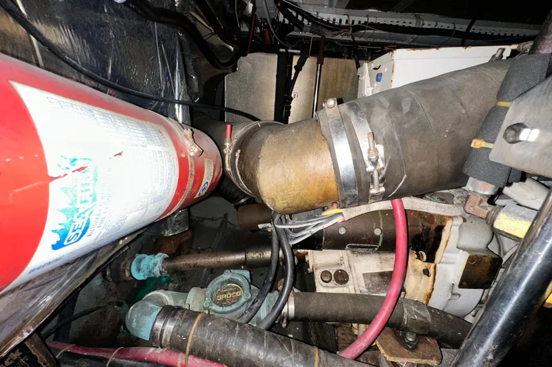 Slide: The Image of Engine room of 1995 Carver 440 Aft Cabin Motor Yacht with fire extinguisher and hoses. - 83