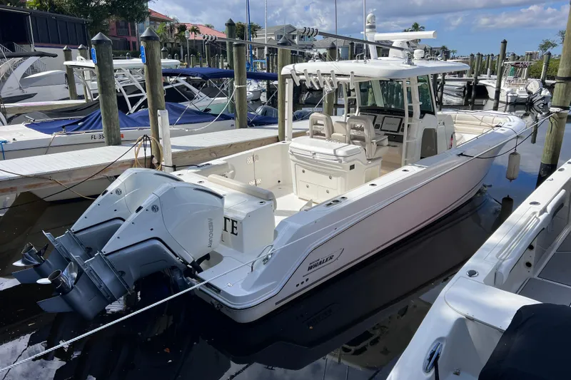 Slide: The Image of 2021 Boston Whaler 330 Outrage docked, featuring dual Mercury outboard engines. - 11