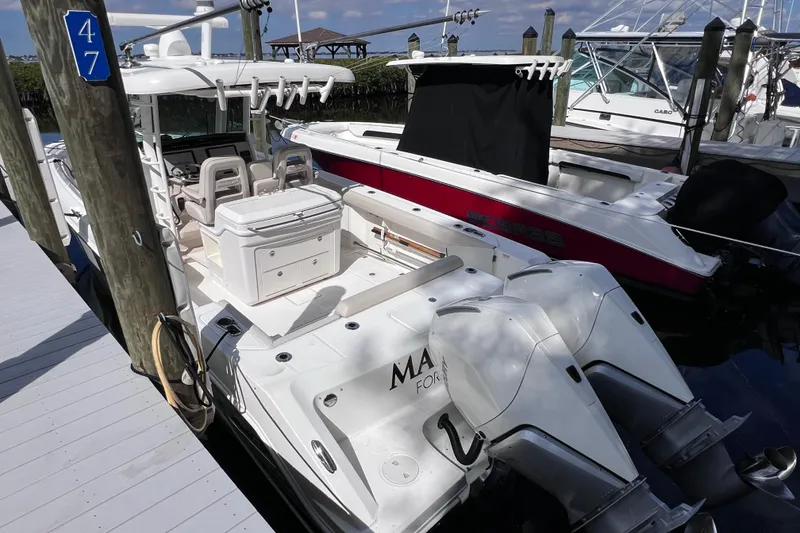 Slide: The Image of 2021 Boston Whaler 330 Outrage docked with twin engines, showcasing spacious deck layout. - 13
