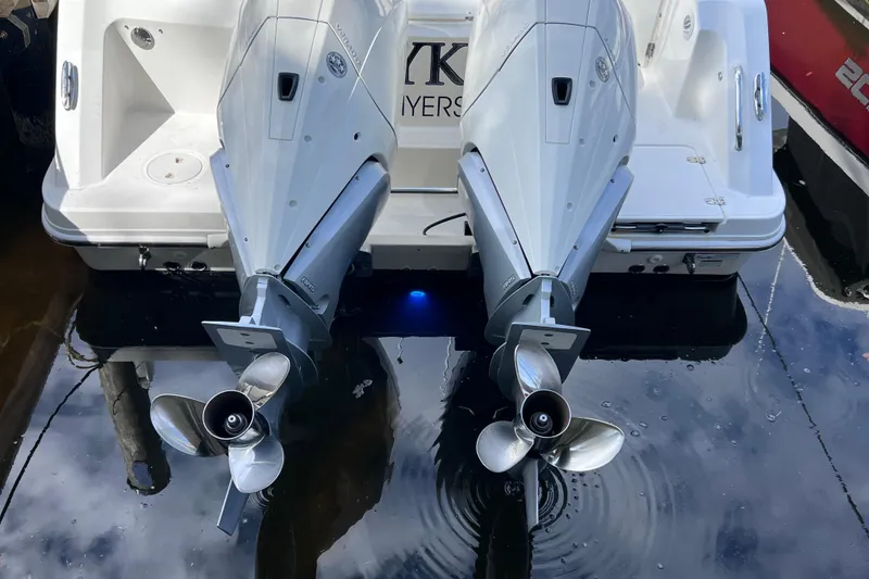 Slide: The Image of 2021 Boston Whaler 330 Outrage with dual outboard engines, docked on calm water. - 14