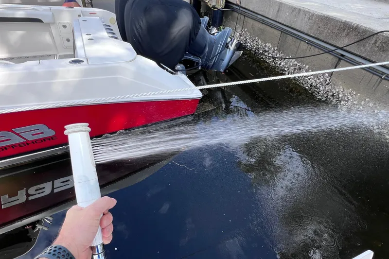 Slide: The Image of Washing a 2021 Boston Whaler 330 Outrage boat with a hose at the dock. - 24
