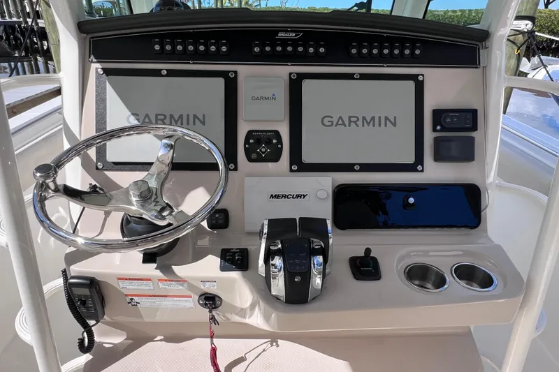 Slide: The Image of Control panel of 2021 Boston Whaler 330 Outrage with Garmin displays and Mercury controls. - 35