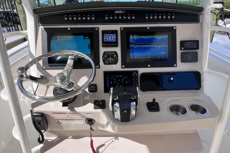 Slide: The Image of Control panel of 2021 Boston Whaler 330 Outrage with navigation screens and steering wheel. - 36