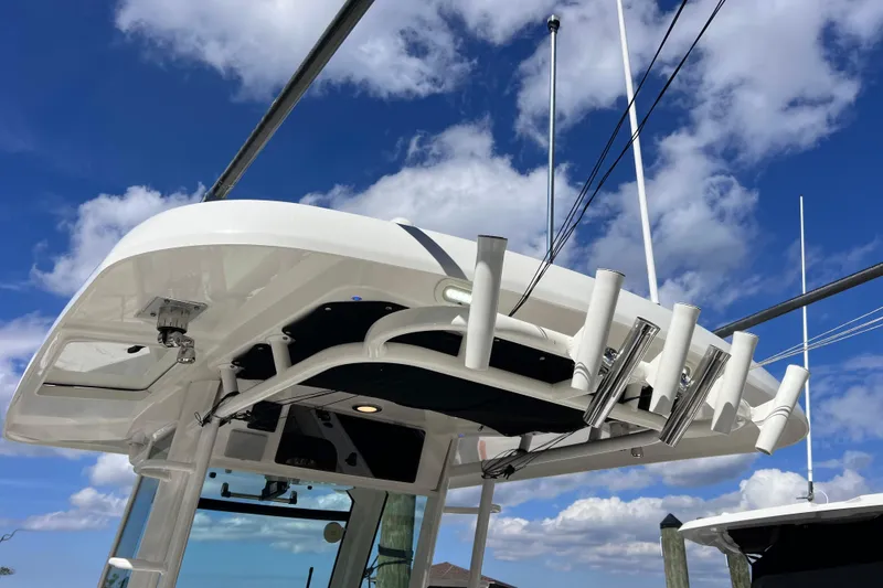 Slide: The Image of Boston Whaler 330 Outrage 2021 boat with rod holders against a blue sky. - 62