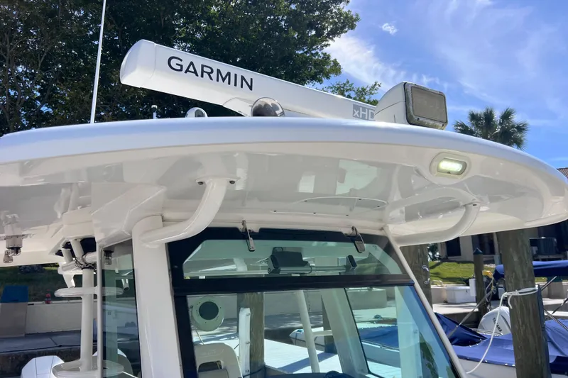 Slide: The Image of 2021 Boston Whaler 330 Outrage with Garmin radar, docked under clear blue sky. - 64