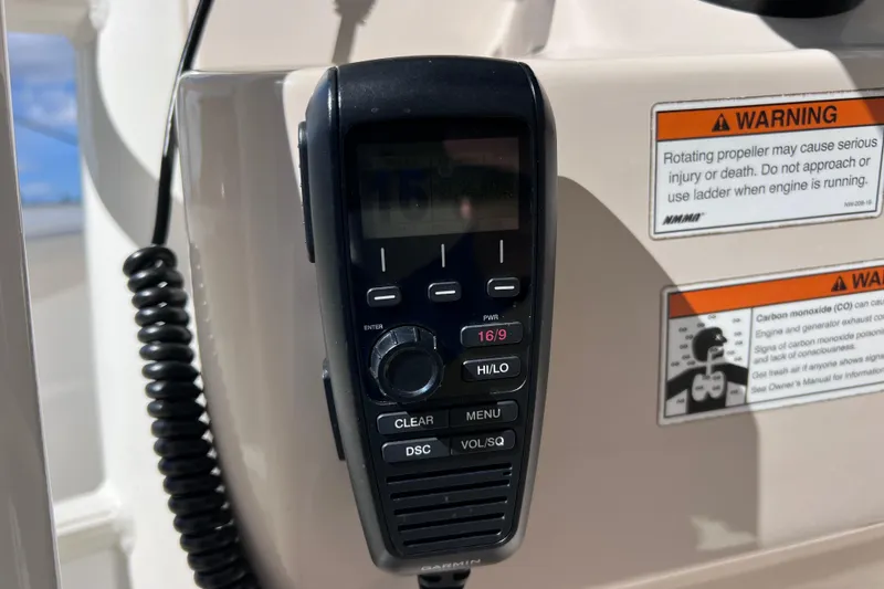 Slide: The Image of VHF radio on 2021 Boston Whaler 330 Outrage boat with safety warnings. - 73