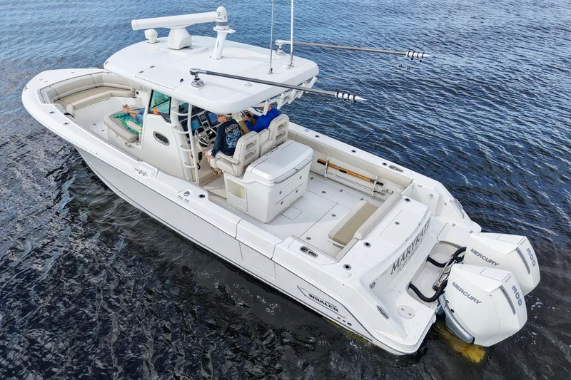 Slide: The Image of 2021 Boston Whaler 330 Outrage boat on water, featuring dual Mercury engines. - 8