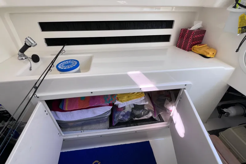 Slide: The Image of 2021 Boston Whaler 330 Outrage interior storage with fishing gear and accessories. - 82