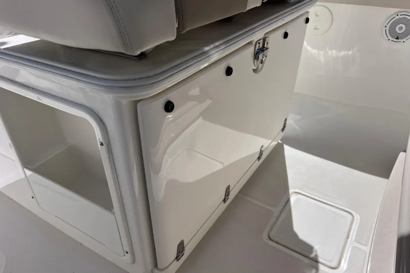 Slide: The Image of 2021 Boston Whaler 330 Outrage interior storage compartment, featuring sleek white design. - 83