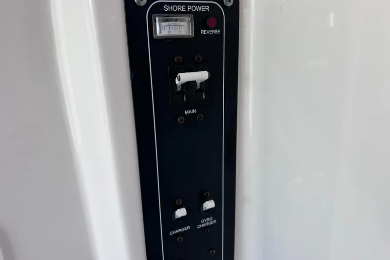Slide: The Image of Control panel on 2021 Boston Whaler 330 Outrage boat, featuring shore power and charger switches. - 85