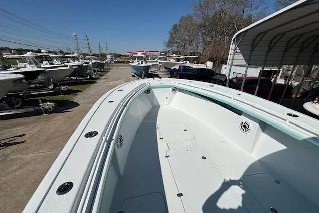 Slide: The Image of 2024 Yellowfin 36 Offshore boat, spacious deck, parked in a marina under clear blue sky. - 17