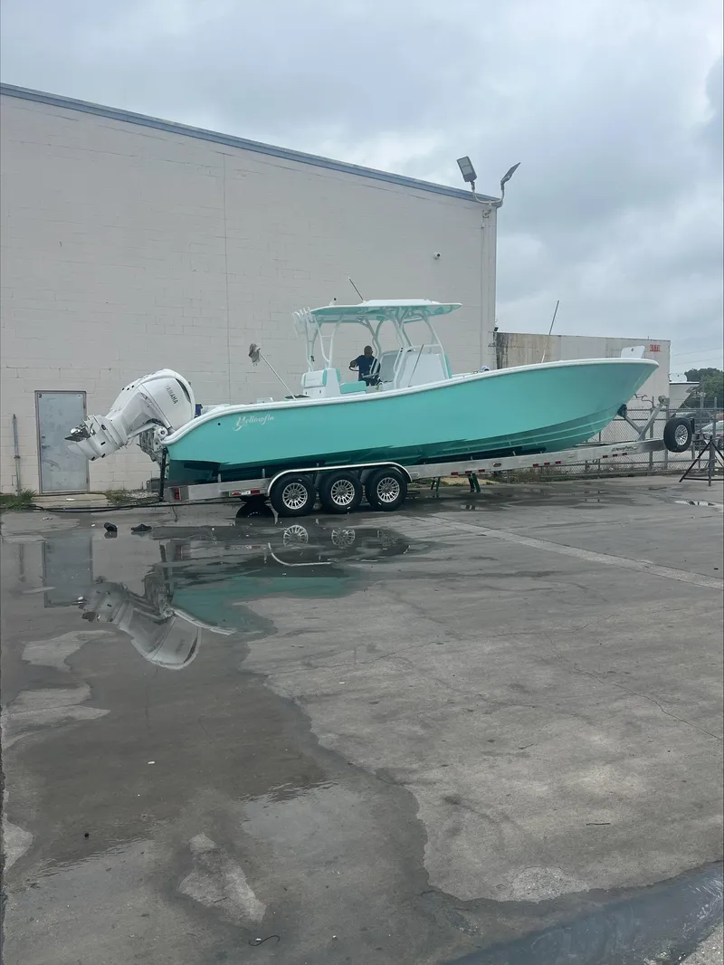 Slide: The Image of 2024 Yellowfin 36 Offshore boat on a trailer outside a warehouse. - 2