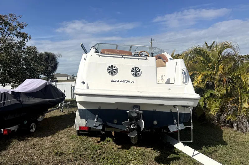 The Image of 1998 Bayliner 2355 Ciera boat on trailer, parked outdoors under a clear blue sky. - 0